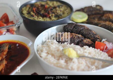 Plats au Kerala avec riz rouge, curry de sardines, friture de sardine et curry de gramme vert à base de noix de coco. Tous préparés dans le style traditionnel du kerala Banque D'Images