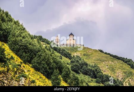 Église de la Trinité du XIVe siècle de Gergeti près du village de Gergeti En Géorgie, près de la frontière nord avec la Russie Village de Stepantsminda o Banque D'Images