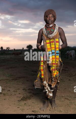 Portrait de la femme Hamer au lever du soleil: Femme Hamer dans un champ où le bétail de la tribu se trèze. Étant principalement pasteurs, le Hamer, ou Hamar groupe pr Banque D'Images