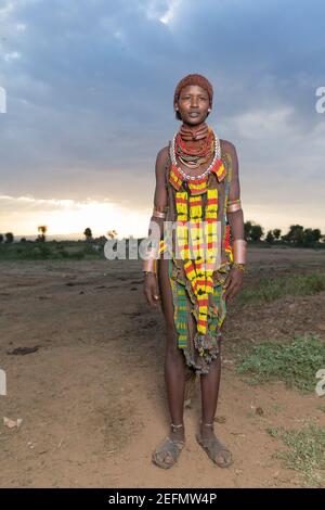 Femme Hamer au lever du soleil: Femme Hamer dans un champ où le bétail de la tribu se brout. Étant principalement des pasteurs, le groupe Hamer ou Hamar accorde leur c Banque D'Images