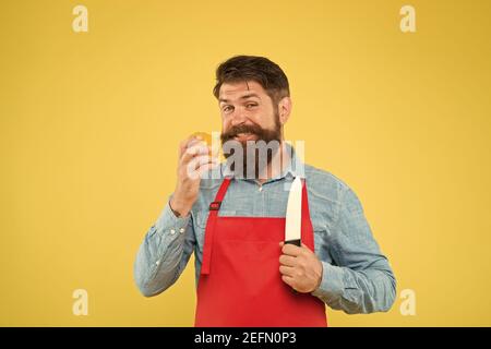 Le chef prépare le repas. Homme barbu préparer la tomate. Recette de salade fraîche. Homme mûr tenir couteau et légumes. Coupe sûre. Couper des légumes. Liste ultime des techniques de coupe que chaque chef devrait savoir. Banque D'Images