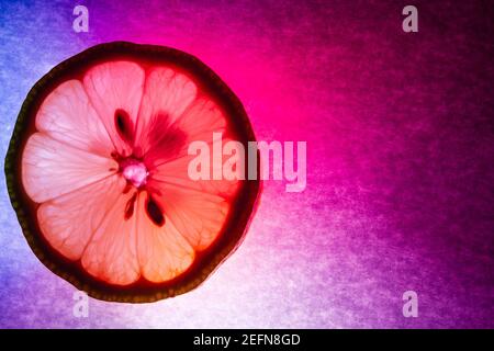 Une fine coupe de citron macro capture, coloriement éclairé et rétro-éclairé Banque D'Images