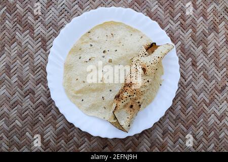 En-cas indien savoureux très apprécié, mangé avec déjeuner et dîner ou juste en-cas. Papad ou papapadoms. Papapas rôtis et frits servis dans une assiette blanche Banque D'Images