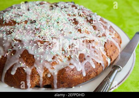 Vue latérale d'un gâteau au citron de blé entier avec du sucre givrage sur une plaque Banque D'Images