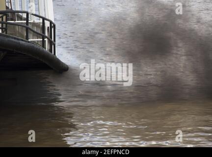 La fumée noire du bateau à vapeur se répand sur la surface de l'eau Banque D'Images