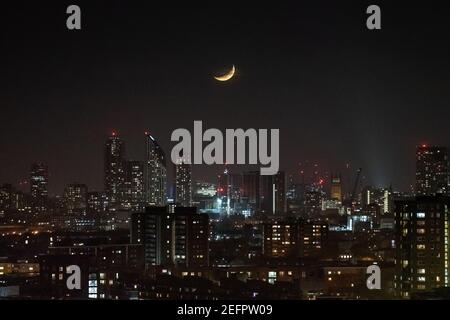 Londres, Royaume-Uni. 16 février 2021. Météo au Royaume-Uni : une lune de Crescent qui se dresse à la fin du mardi au-dessus de la ville en suivant une direction nord-ouest. Credit: Guy Corbishley/Alamy Live News Banque D'Images