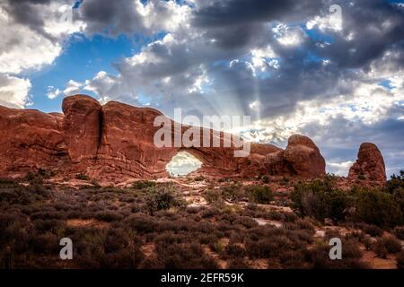 La section de la fenêtre, l'arche de la fenêtre sud avec les premiers rayons du soleil de la journée derrière dans le parc national d'Arches, Utah Banque D'Images