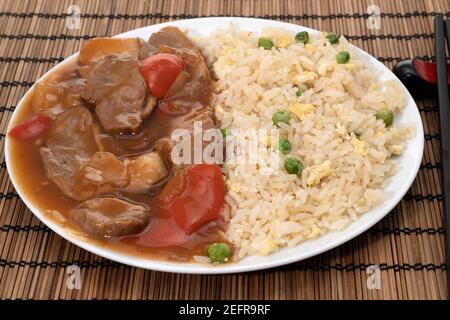 Tranche de canard dans une riche sauce prune servie avec un œuf et du riz frit Banque D'Images