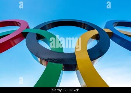 Cinq anneaux entrelacés en bleu, noir, rouge, jaune et vert sur fond bleu Banque D'Images