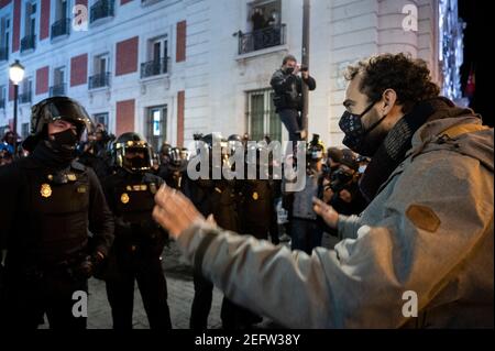 Madrid, Espagne. 17 février 2021. Un manifestant fait face à la police lors d'une manifestation contre l'emprisonnement du rappeur espagnol Pablo Hasel pour quelques paroles de chansons et tweets critiquant la monarchie espagnole. Credit: Marcos del Mazo/Alay Live News Banque D'Images