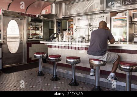 Un homme est assis au comptoir du restaurant rétro de la 11th Street Diner à Miami Beach, en Floride. Banque D'Images