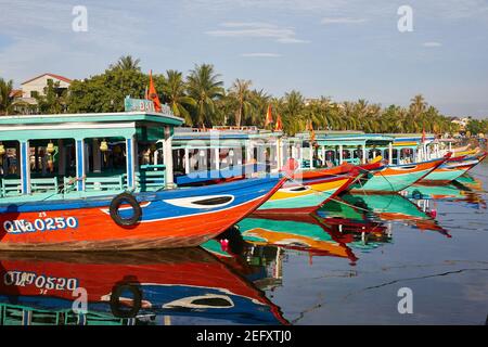 Bateaux d'excursion alignés le long du quai sur la rivière Thu bon, Hoi an, Vietnam Banque D'Images