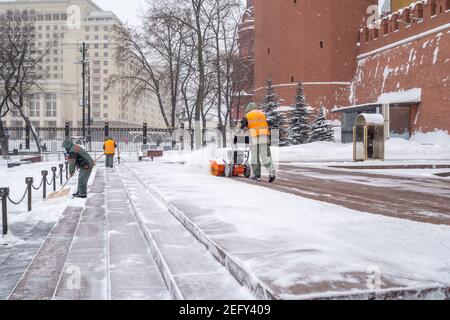 Moscou. Russie. 12 février 2021. Les employés des services publics retirent la neige à l'aide d'un souffleur à neige et de pelles lors d'une chute de neige près du mur du Kremlin, à la tombe de Banque D'Images