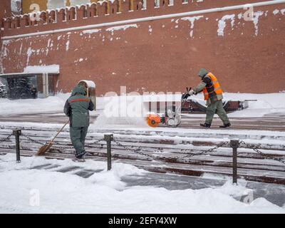 Moscou. Russie. 12 février 2021. Les employés des services publics retirent la neige à l'aide d'un souffleur à neige et de pelles lors d'une chute de neige près du mur du Kremlin, à la tombe de Banque D'Images