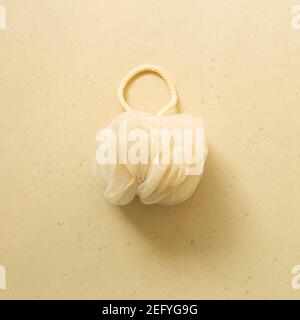 Boule de douche. Éponge de douche sur fond beige. Salle de bains. Vue sur le dessus Banque D'Images