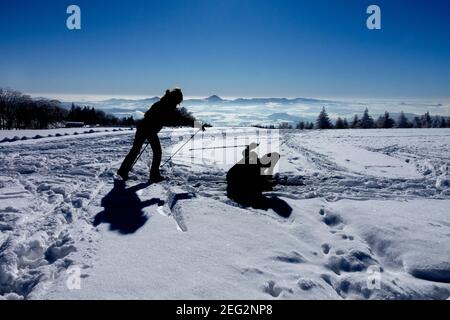 Silhouettes d'une paire de skieurs profitant d'un beau soleil journée dans un paysage enneigé Banque D'Images