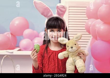 Enfant mignon avec œufs de Pâques. Petite fille mignonne portant des oreilles de lapin. Banque D'Images