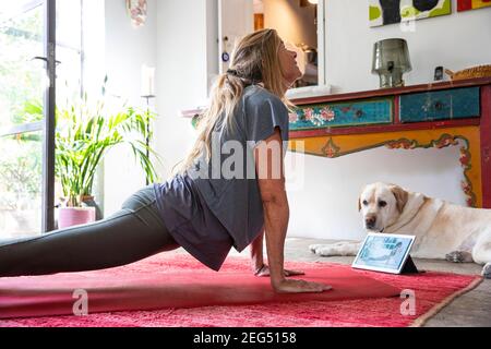 Femme dans ses années 50 faisant le yoga en ligne Banque D'Images