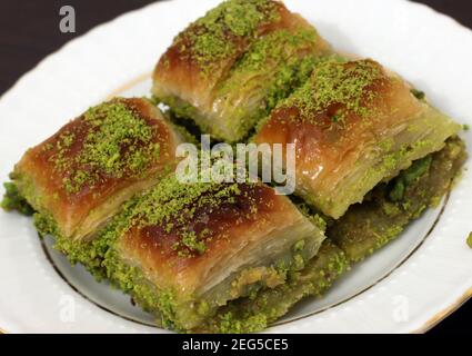 Dessert turc traditionnel Antep Baklava avec pistache sur table rustique, ramadan ou desserts de vacances. Antep Baklavasi. Banque D'Images
