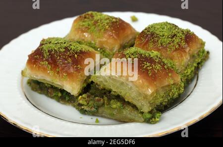 Dessert turc traditionnel Antep Baklava avec pistache sur table rustique, ramadan ou desserts de vacances. Antep Baklavasi. Banque D'Images