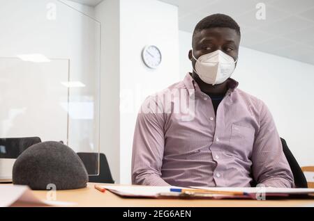 Stuttgart, Allemagne. 18 février 2021. Un réfugié du Cameroun est assis dans une salle du tribunal administratif de Stuttgart avant le début du procès. Le procès de l'homme contre l'État de Baden-Württemberg commence au tribunal administratif de Stuttgart. Il conteste ce qu'il considère être une action disproportionnée de la police lors d'une opération au centre d'accueil initial (LEA) à Ellwangen et lors de sa déportation en 2018. Credit: Marijan Murat/dpa/Alamy Live News Banque D'Images