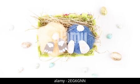 deux petits pains artisanaux de pâques moelleux faits à la main et œufs colorés dans un panier avec foin. Pâques, vacances et célébration concept. Carte de vœux. Sélectif FO Banque D'Images