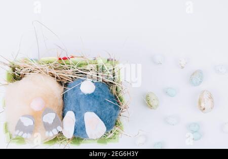 deux petits pains artisanaux de pâques moelleux faits à la main et œufs colorés dans un panier avec foin. Pâques, vacances et célébration concept. Carte de vœux. Sélectif FO Banque D'Images