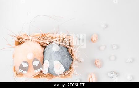 deux petits pains artisanaux de pâques moelleux faits à la main et œufs colorés dans un panier avec foin. Pâques, vacances et célébration concept. Carte de vœux. Sélectif FO Banque D'Images