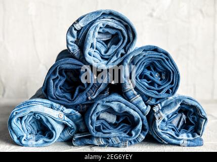 rouler le jean denim bleu sur fond gris Banque D'Images