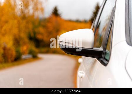 Gros plan d'un miroir extérieur d'un véhicule ou d'une voiture blanc - concept de transport, vacances d'automne ou vacances d'automne et tournée - dans le backgroun Banque D'Images