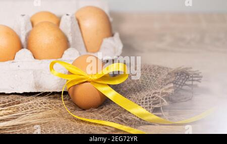 Oeufs de Pâques avec un ruban d'or sur un Burlap sur un fond clair. Bannière concept joyeuses Pâques. Copier l'espace, Flat lay Banque D'Images