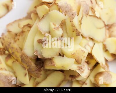 Éplucher les pommes de terre sur une assiette. Banque D'Images