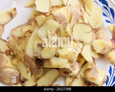 Éplucher les pommes de terre sur une assiette. Banque D'Images