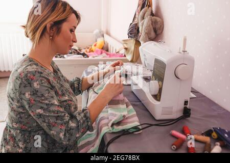 la fille est engagée dans la couture à la maison sur un machine à coudre Banque D'Images