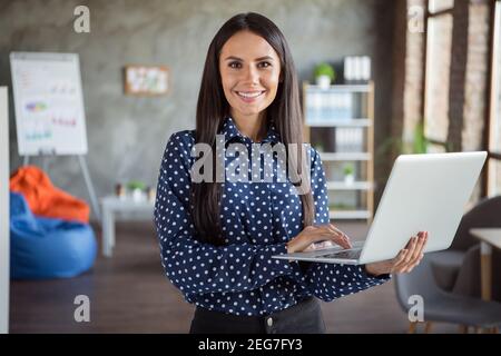 Photo de jeune attrayant beau sourire heureux gai bonne humeur une femme d'affaires tient son ordinateur portable au bureau Banque D'Images