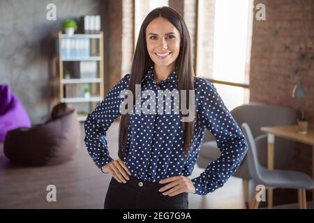 Photo de jeune heureuse gaie positive bonne humeur souriante femme d'affaires en blouse à pois sur le lieu de travail de bureau Banque D'Images