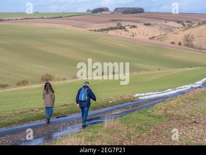 Burdale, North Yorkshire, Angleterre, 16-02-2021 - couple de ramblers marchant sur une route de campagne dans les Yorkshire Wolds en hiver. Banque D'Images