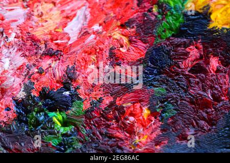 Différentes couleurs vives de peintures à l'huile sont mélangées gros plan Banque D'Images