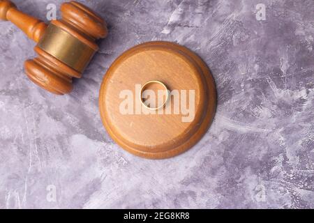 Concept de divorce avec des anneaux de gavel et de mariage sur la table. Banque D'Images