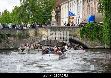 Touristes visitant sur les bateaux de plaisance sur le canal de Dijver à Bruges, Belgique Banque D'Images