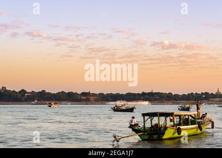 Bagan, Myanmar - vue sur l'Irrawaddy ou sur la rivière Ayeyarwady au coucher du soleil. Bateaux flottant sur la rivière et pagodes sur la terre. Banque D'Images