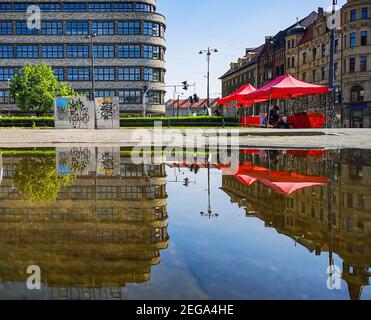 Wroclaw juin 14 2019 Centre commercial de Renoma et tentes rouges avec lunettes de soleil reflétées dans une grande flaque Banque D'Images