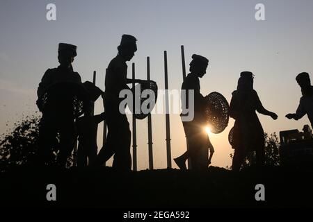 Dhaka, Bangladesh. 18 février 2021. Les travailleurs de jour ont défait du charbon sur leur tête d'un cargo près d'un entrepôt dans la banlieue de Dhaka. Crédit : MD Mehedi Hasan/ZUMA Wire/Alamy Live News Banque D'Images