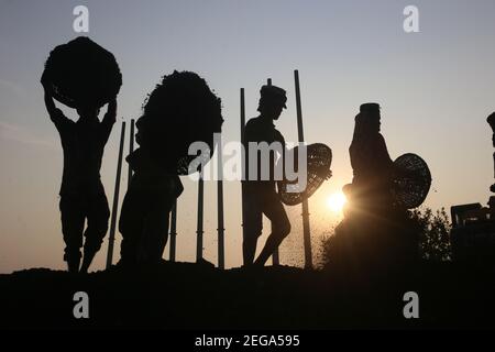 Dhaka, Bangladesh. 18 février 2021. Les travailleurs de jour ont défait du charbon sur leur tête d'un cargo près d'un entrepôt dans la banlieue de Dhaka. Crédit : MD Mehedi Hasan/ZUMA Wire/Alamy Live News Banque D'Images