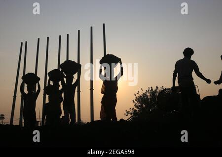 Dhaka, Bangladesh. 18 février 2021. Les travailleurs de jour ont défait du charbon sur leur tête d'un cargo près d'un entrepôt dans la banlieue de Dhaka. Crédit : MD Mehedi Hasan/ZUMA Wire/Alamy Live News Banque D'Images