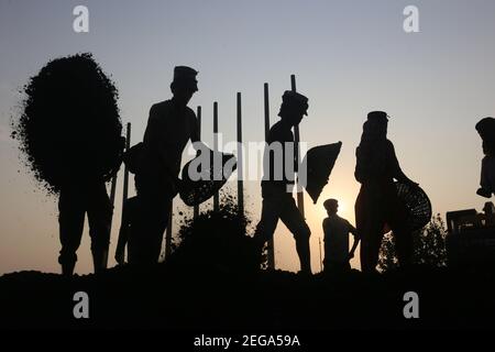 Dhaka, Bangladesh. 18 février 2021. Les travailleurs de jour ont défait du charbon sur leur tête d'un cargo près d'un entrepôt dans la banlieue de Dhaka. Crédit : MD Mehedi Hasan/ZUMA Wire/Alamy Live News Banque D'Images