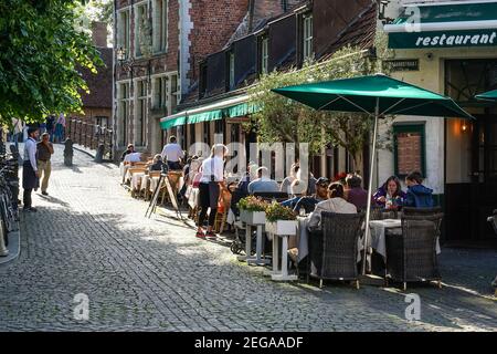 Personnes assises à l'extérieur du restaurant à Bruges, Belgique Banque D'Images