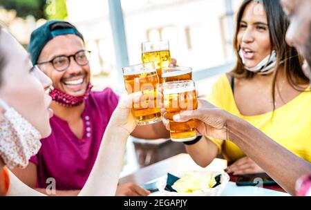 Des amis toaster des verres à bière avec des masques ouverts - Nouveau concept de mode de vie normal avec les gens qui s'amusent ensemble boire happy hour Banque D'Images