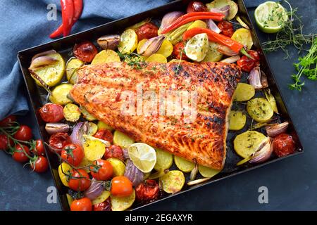 Grand filet de saumon juteux avec une marinade au Chili et au miel, cuit avec des légumes et servi chaud du four sur une plaque de cuisson Banque D'Images