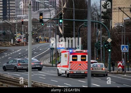 Ambulance de service avec feu bleu et sirène, à un passage de feu, les véhicules font place au véhicule d'urgence, Essen, NRW, Allemagne Banque D'Images